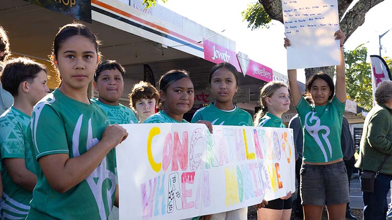 Students from local kura with signs