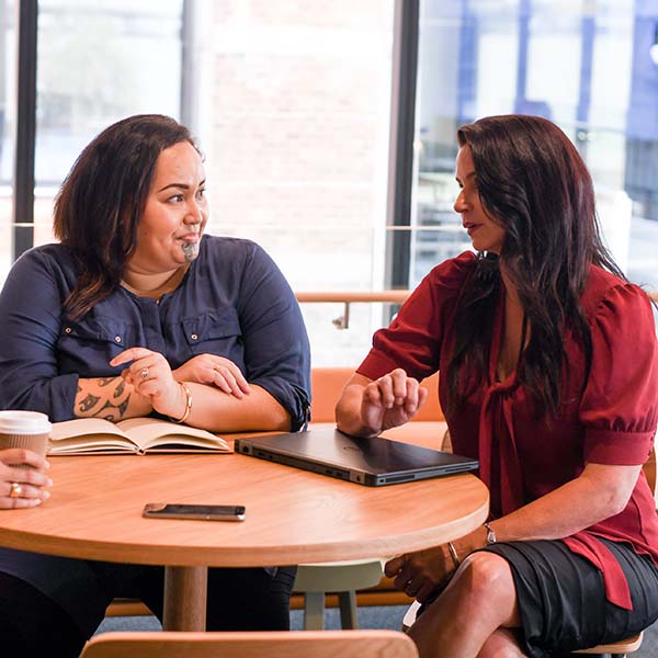 two ladies talking at a table
