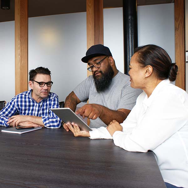 three people sitting in boardroom